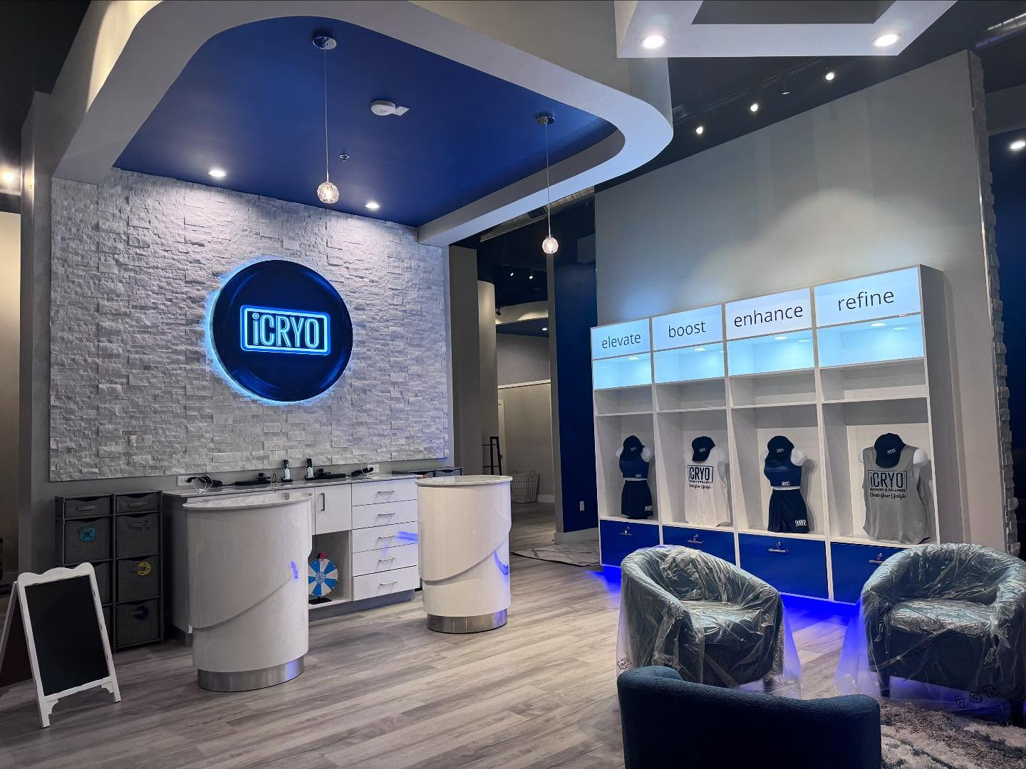 White kitchen with stainless steel appliances, a center island, and overhead lighting.