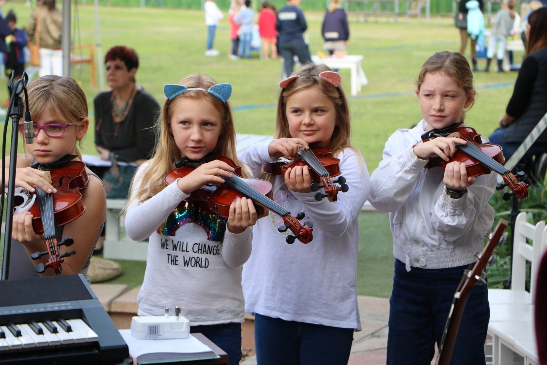 A group of young girls are playing violins in a band.