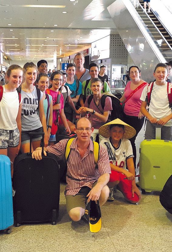 a group of people posing for a picture with luggage at an airport