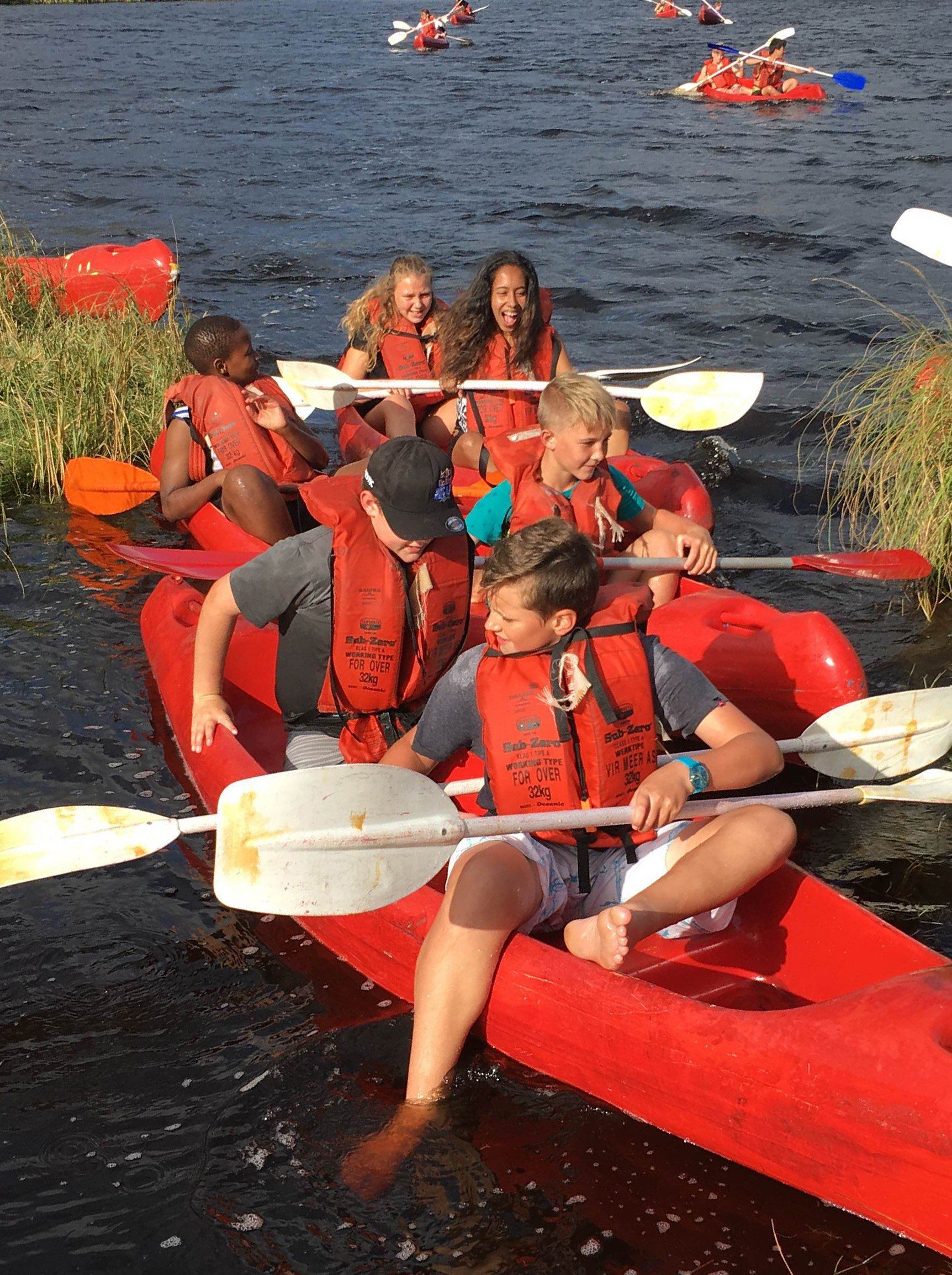 a group of people are rowing kayaks on a lake .