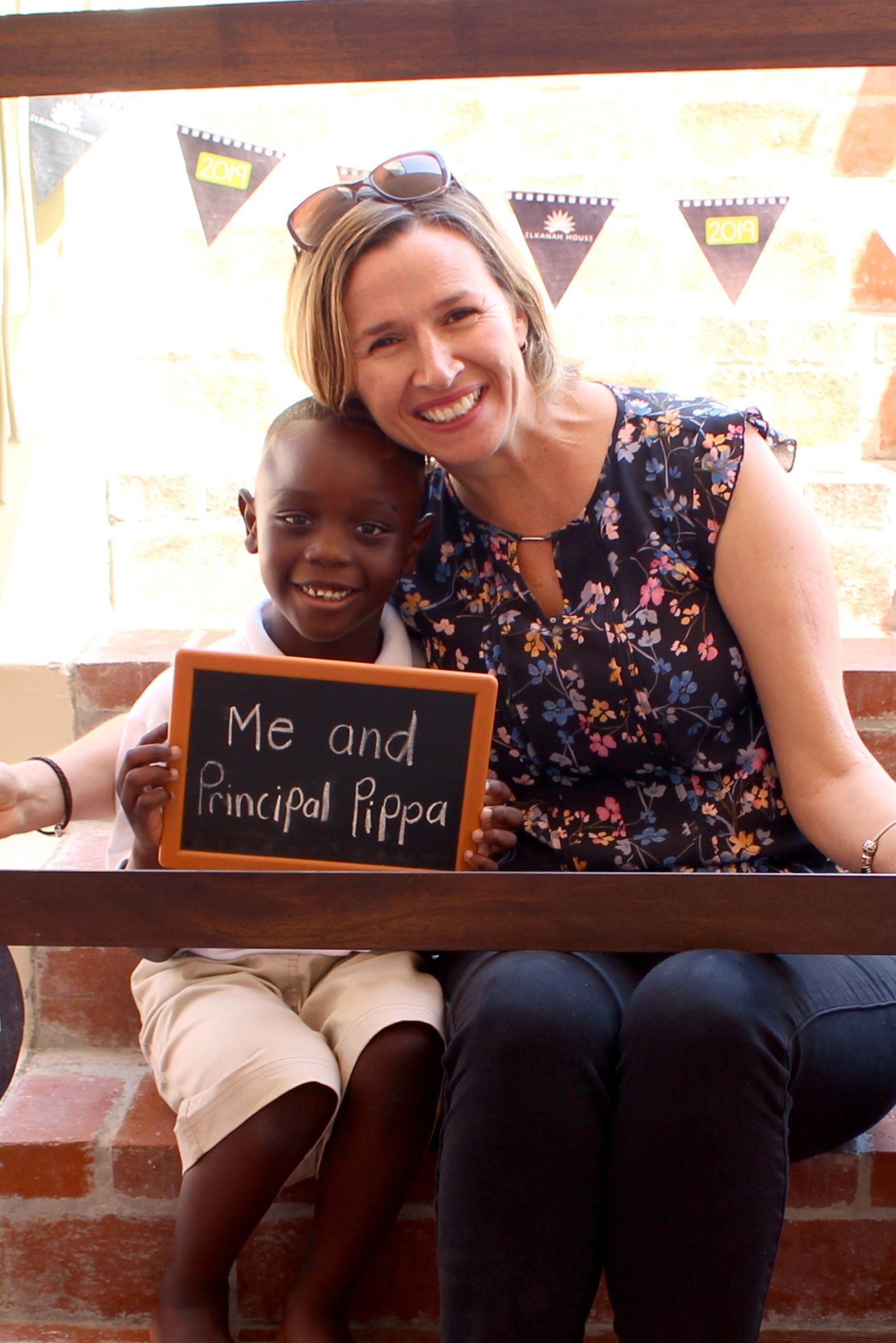 a woman is holding a sign that says me and principal pippa
