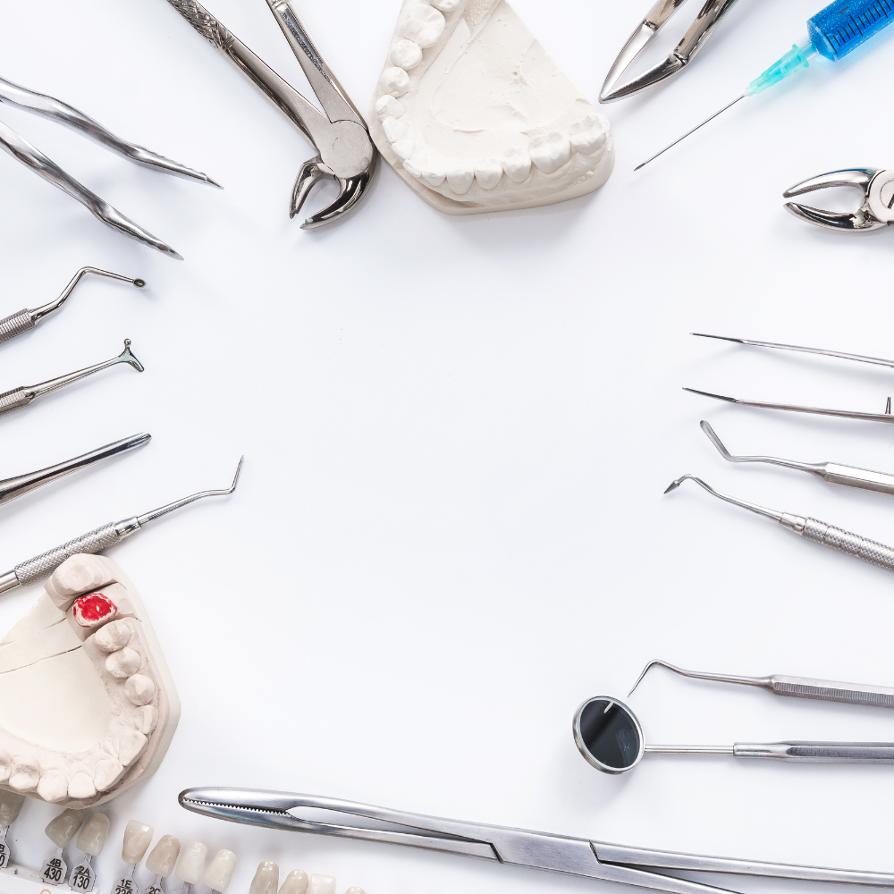 Dental tools and a model of teeth on a white surface