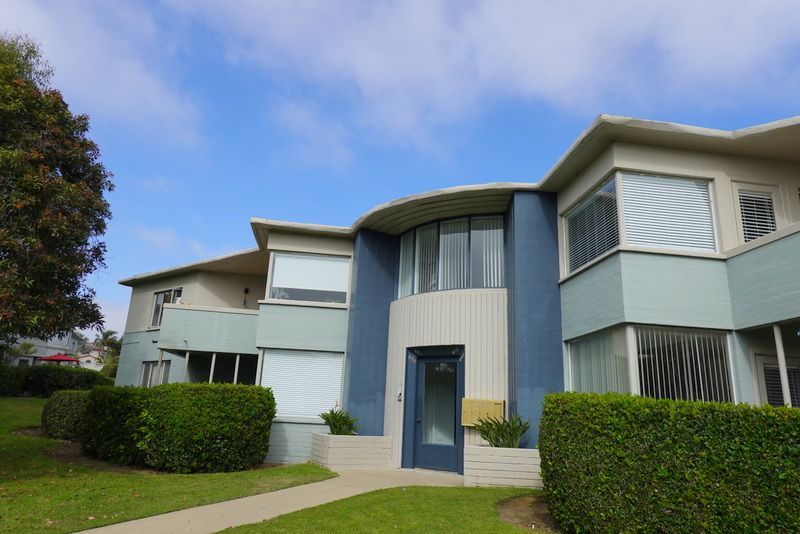 A large house with a lot of windows and a blue door