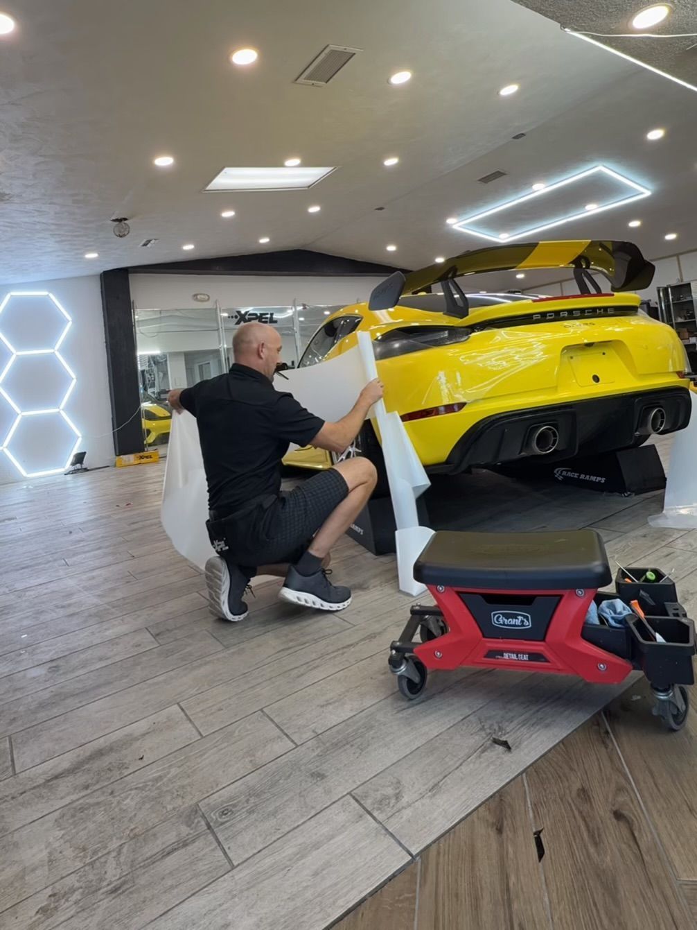 Silver BMW M4 with black accents, in a garage.