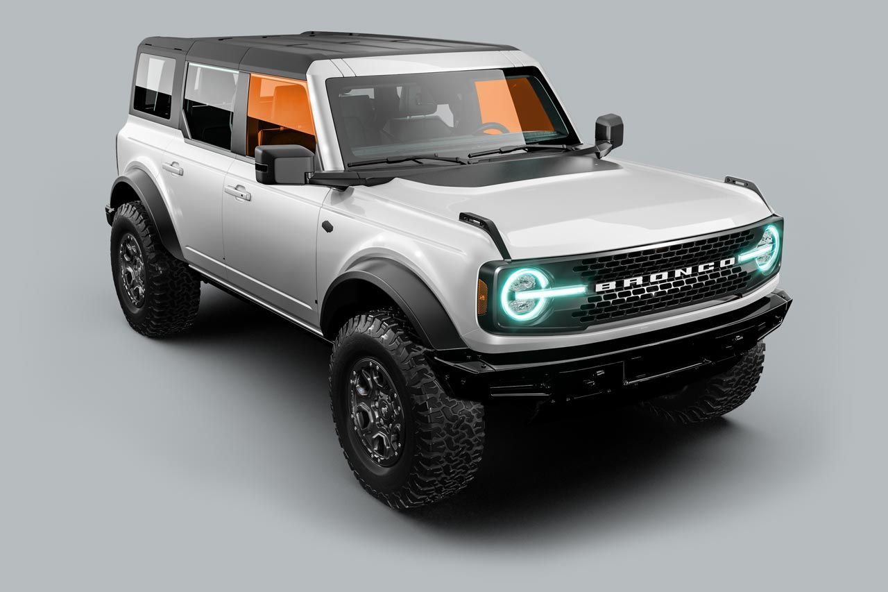 White Ford Bronco SUV with black accents, off-road tires, and orange-tinted windows.