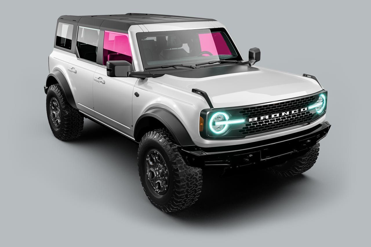 White Ford Bronco SUV with black accents, pink tinted windows, and glowing headlights.