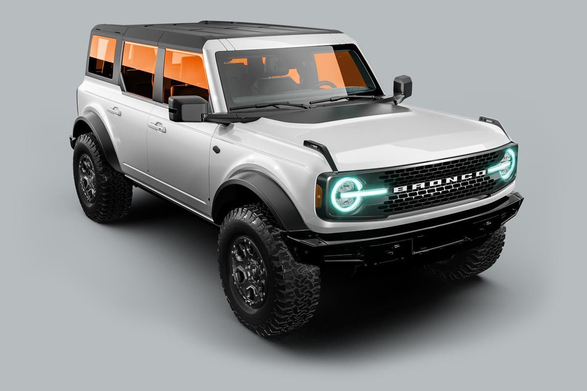 White Ford Bronco SUV with black accents, off-road tires, and orange-tinted windows.