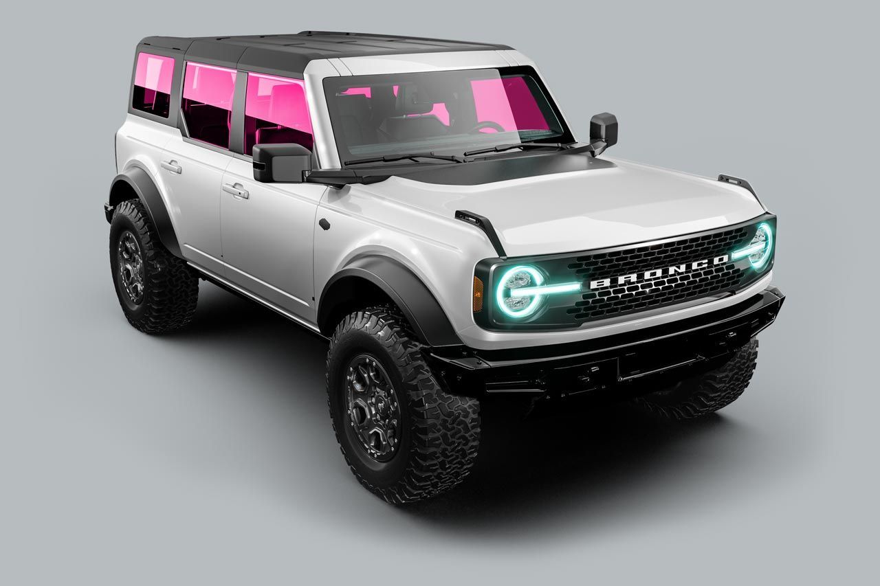 White Ford Bronco with black accents, neon headlights, pink tinted windows on gray background.