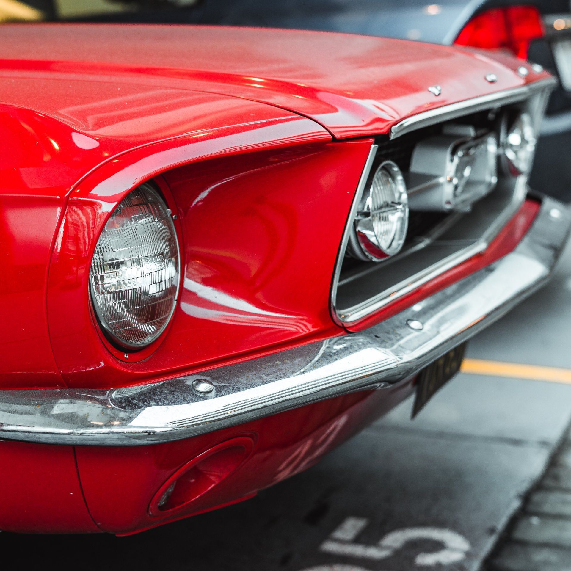 A photo of an old classic For Mustang. The car is red and the paint is glossy.