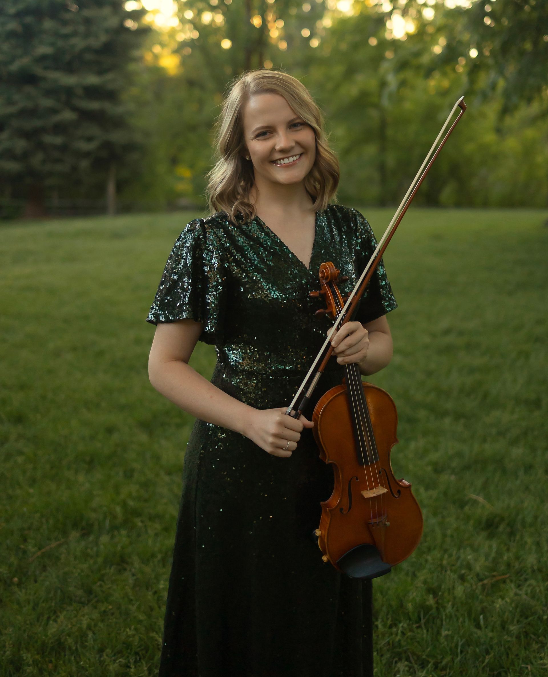 Two women are standing next to each other holding violins.