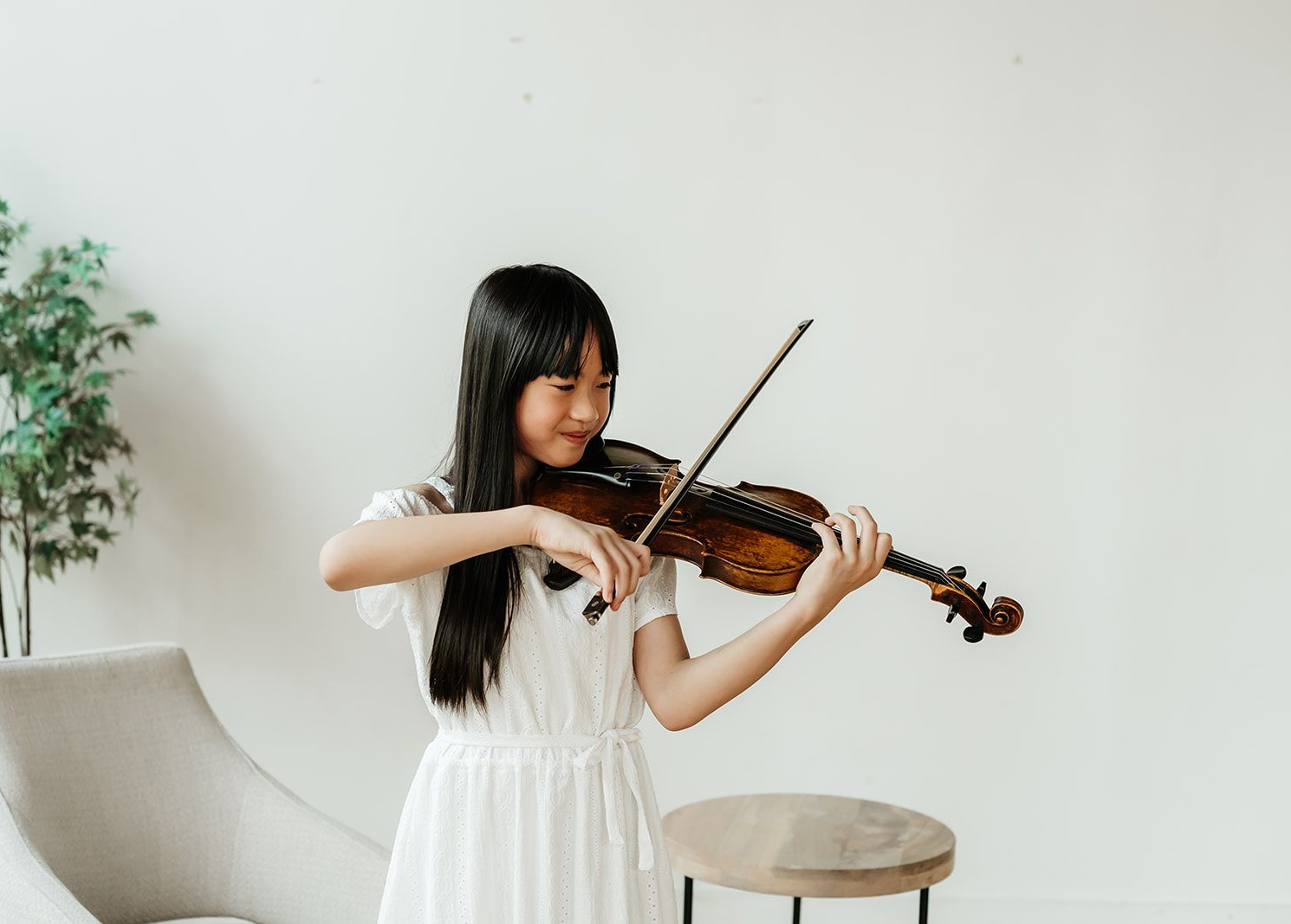 A teenage child is playing the violin.