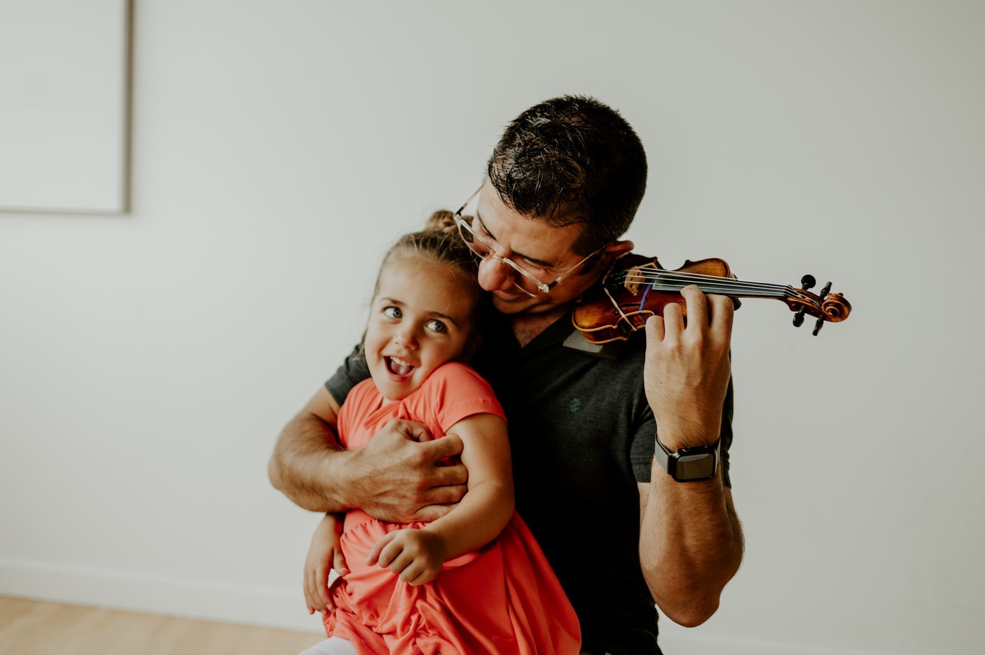 A group of children are playing violins in a room with a teacher.