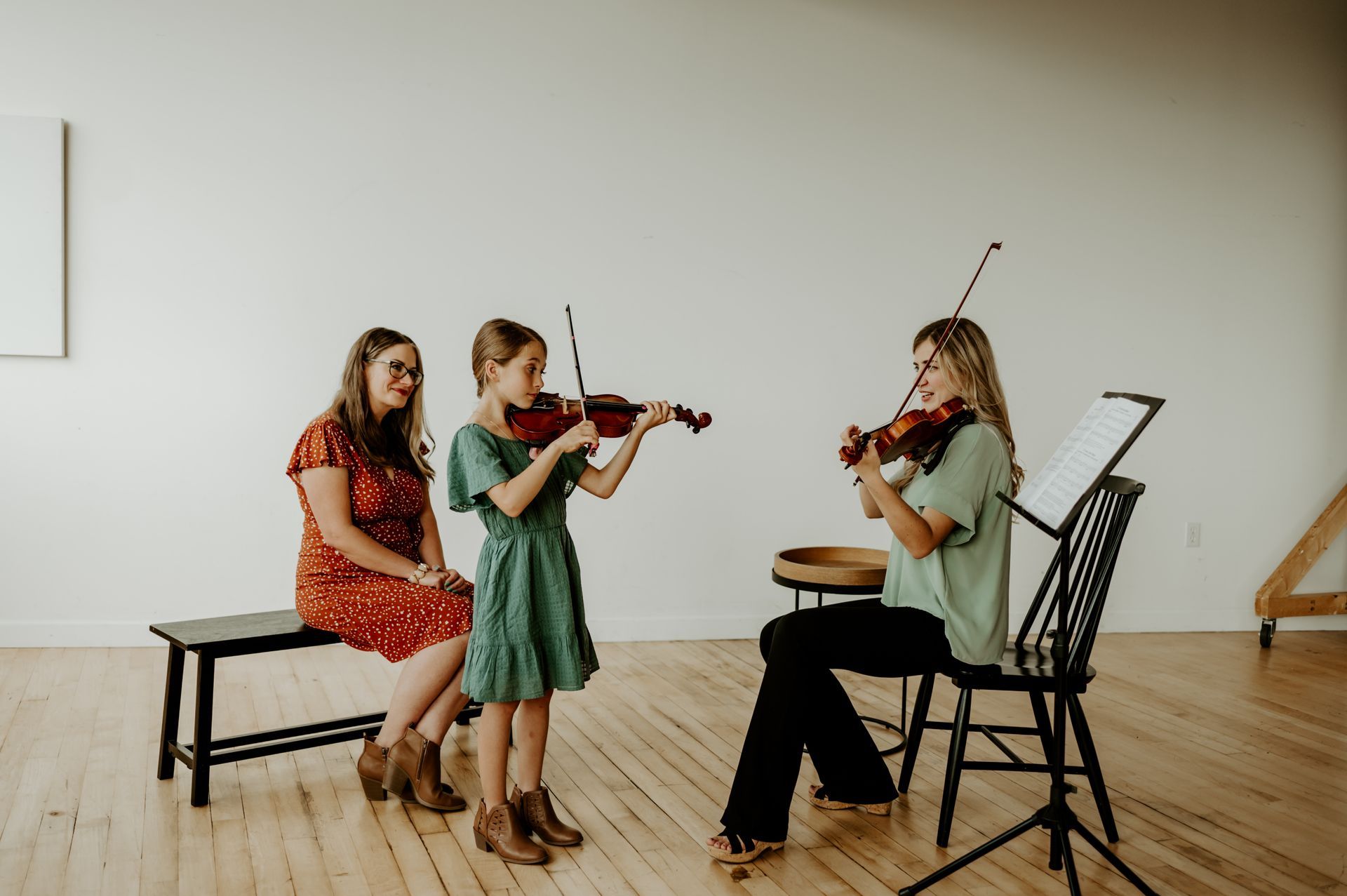 A group of people standing next to each other holding violins and cello.