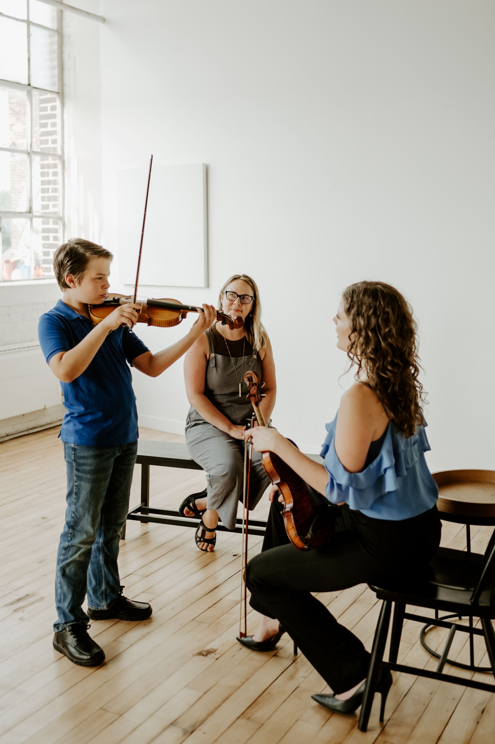 A group of people are playing violins in a room.