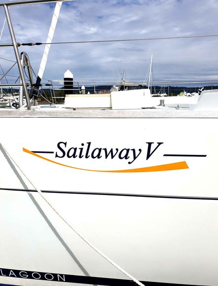 A sailboat with the name sailaway v on the side- Sponsorship Signage in Port Douglas, QLD