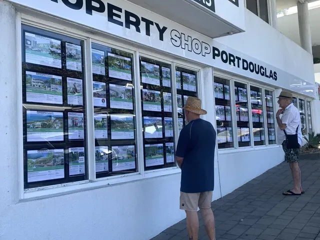 A man standing in front of a property shop- Sponsorship Signage in Port Douglas, QLD