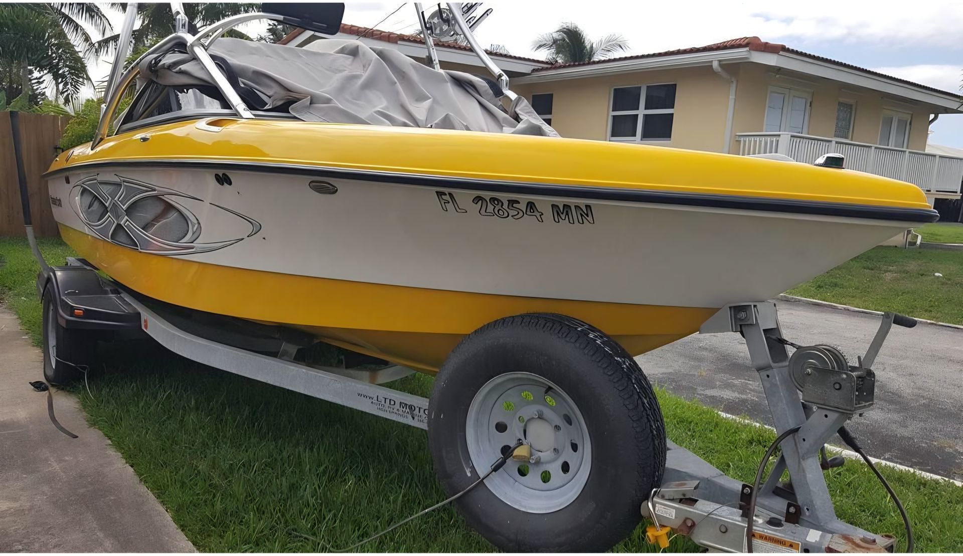 A person is cleaning a blue car with an orange towel