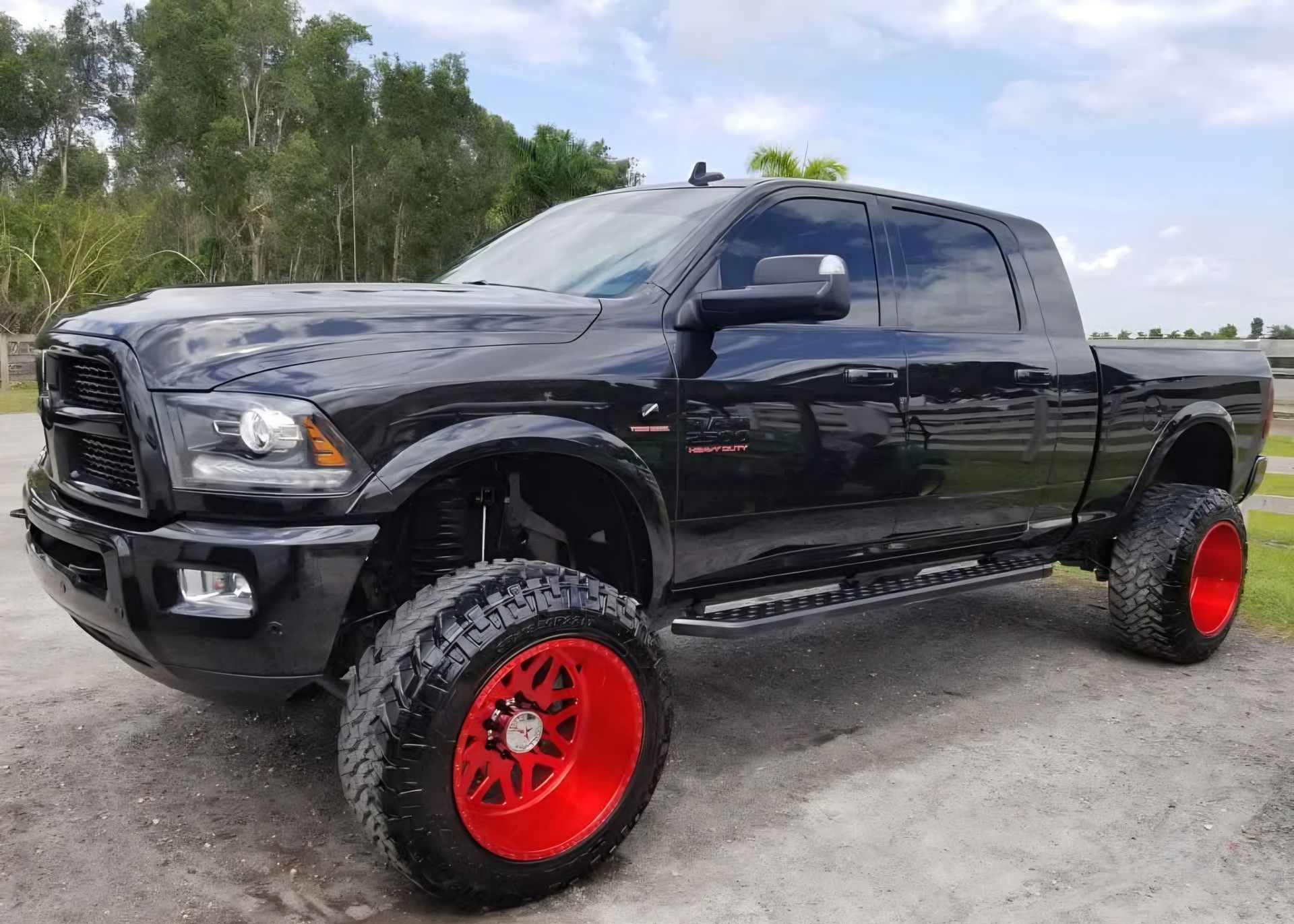 A person is cleaning a blue car with an orange towel