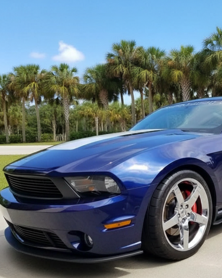 A car is covered in plastic wrap in a garage.