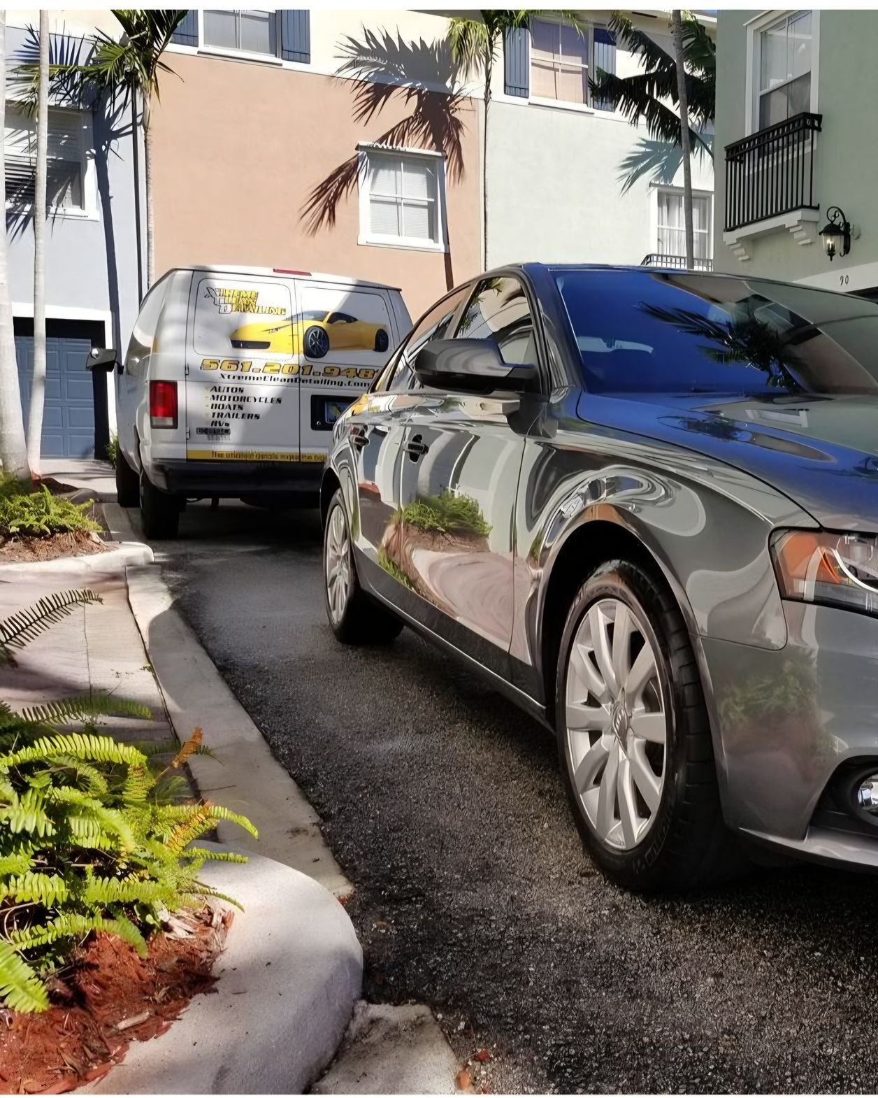 A man is cleaning the wheel of a black car with a sponge.