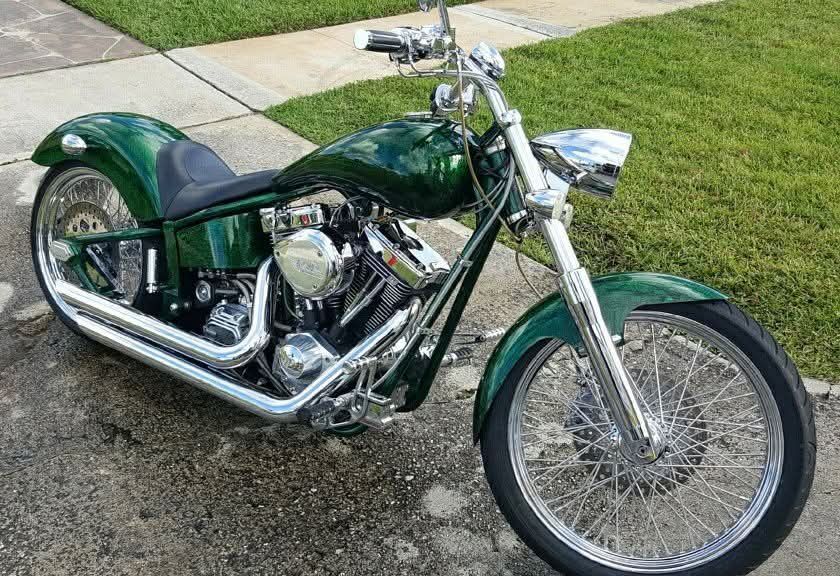 A person is cleaning a blue car with an orange towel