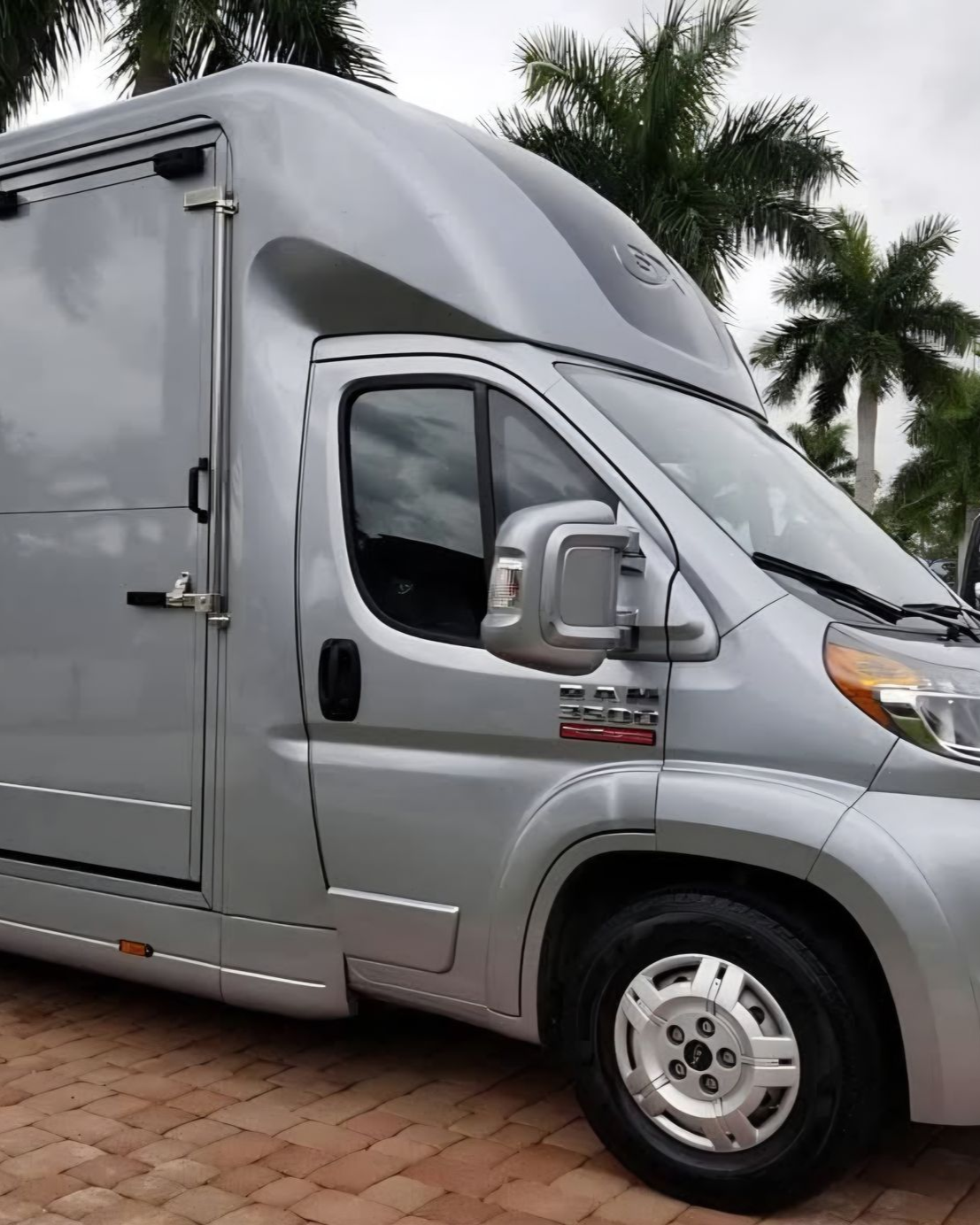 A person wearing black gloves is polishing the hood of a red car.