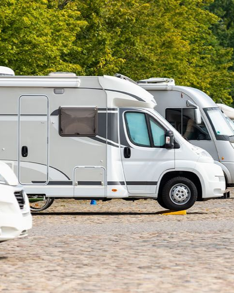 A person is cleaning a blue car with an orange towel