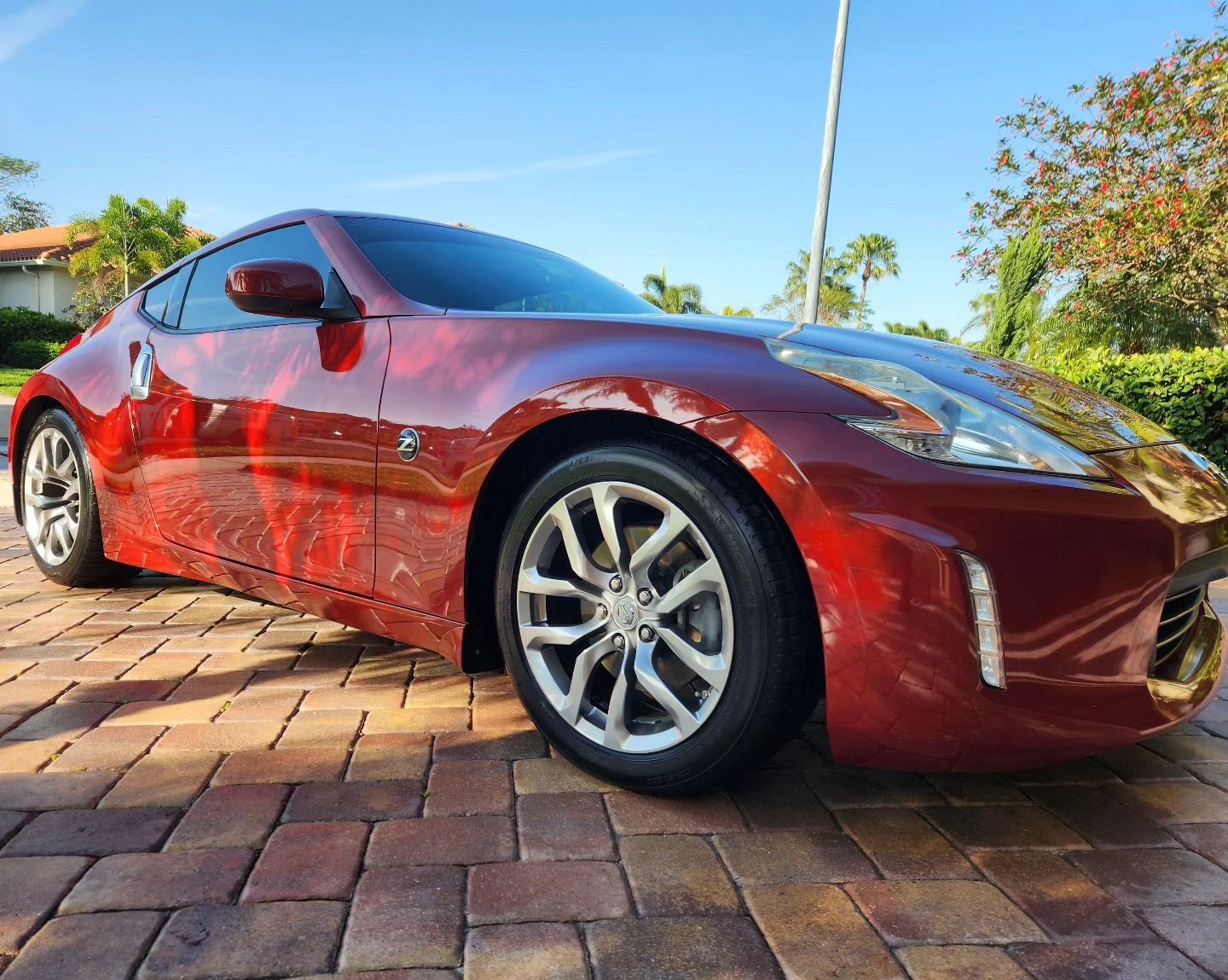 A person is cleaning a blue car with an orange towel