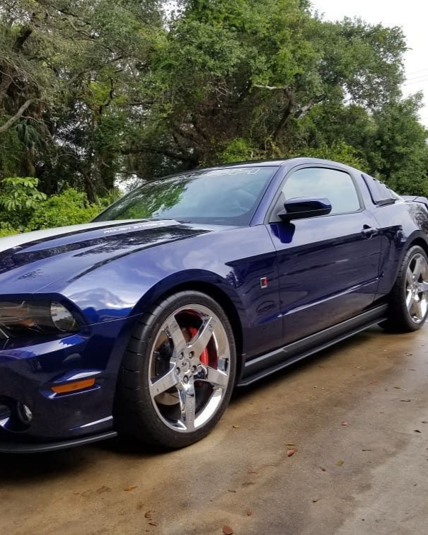 A yellow sports car is parked in a garage.
