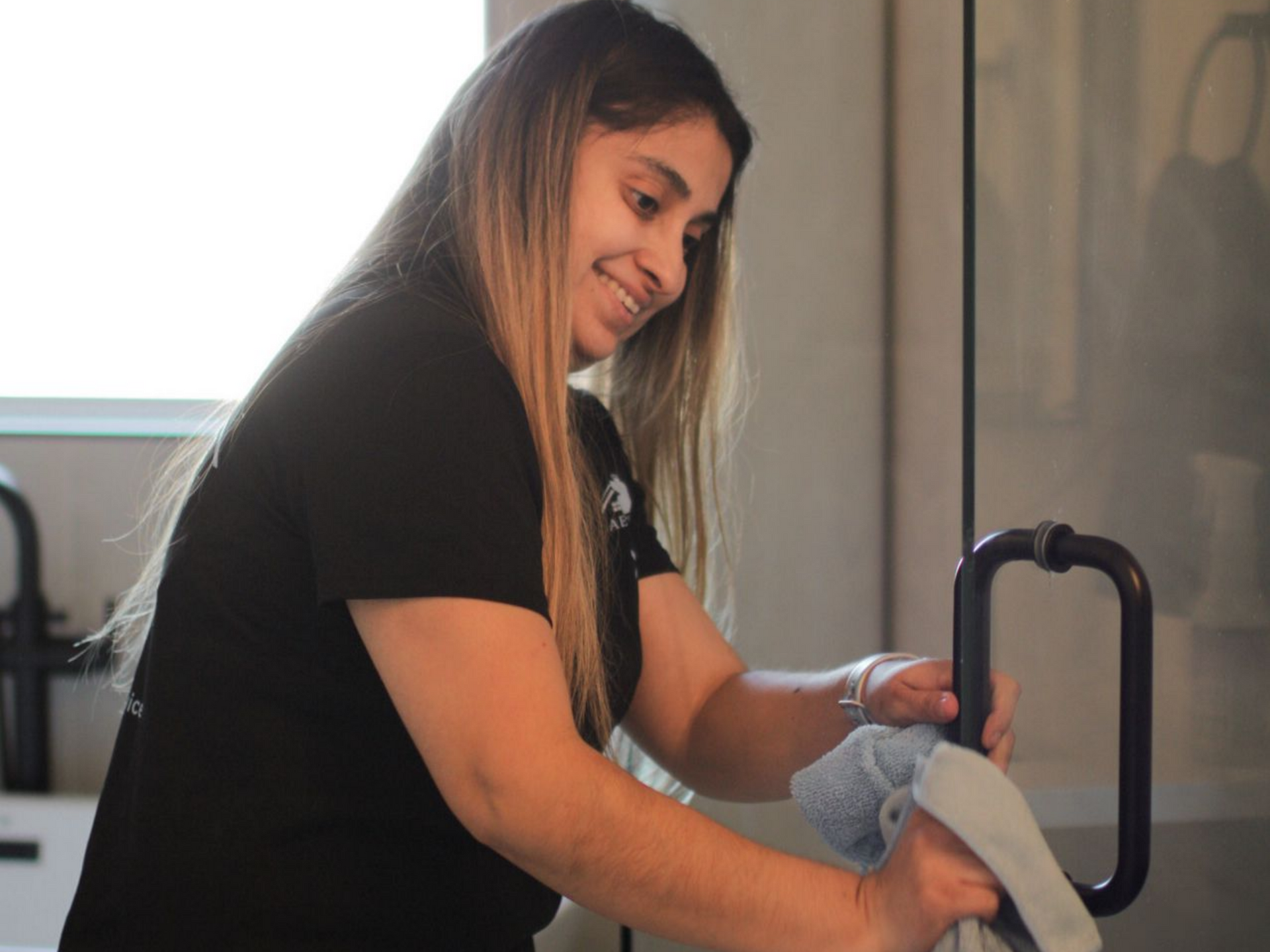 Person using a floor polishing machine in a modern building with reflective flooring. Person using a floor polishing machine in a modern building with reflective flooring.
