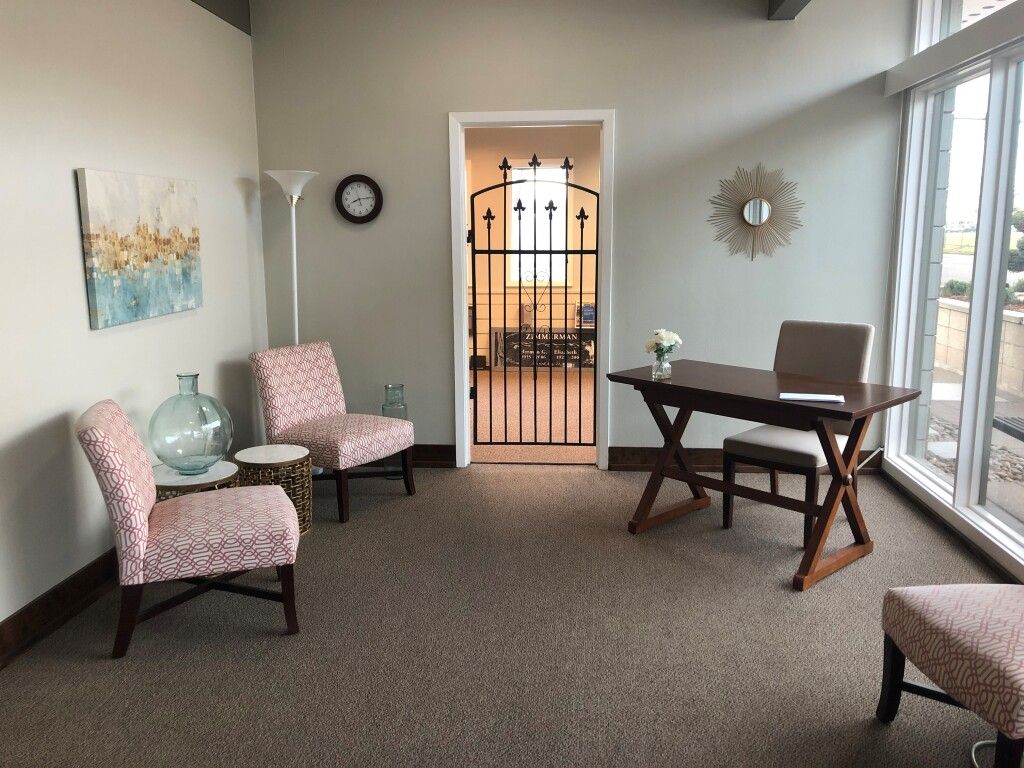 Office with two patterned chairs, desk, large windows, and a gated doorway.