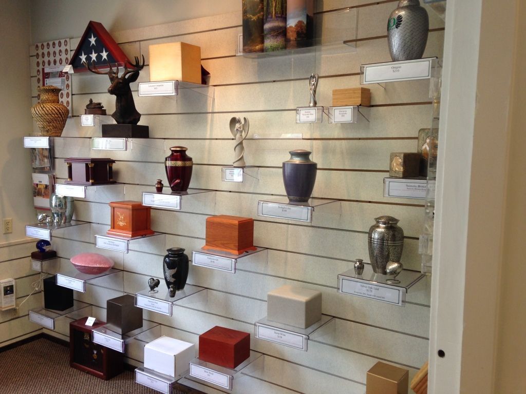 Display of urns and keepsakes on shelves in a funeral home.