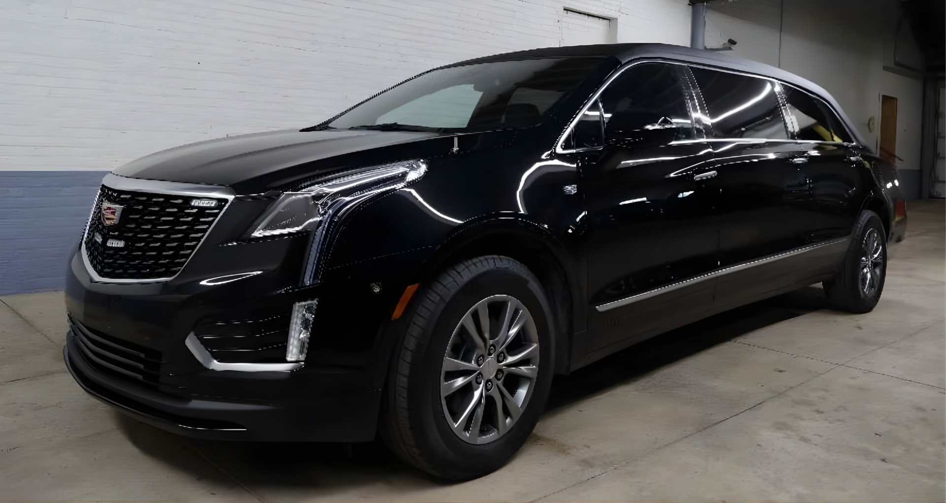 Black Cadillac XT5 SUV parked in a garage.