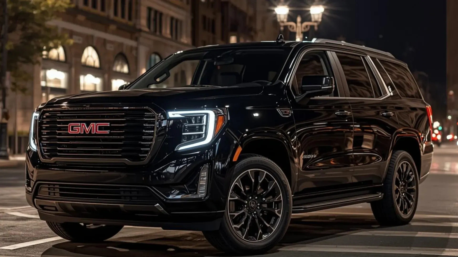 Black GMC Yukon SUV on a city street at night, illuminated by streetlights.