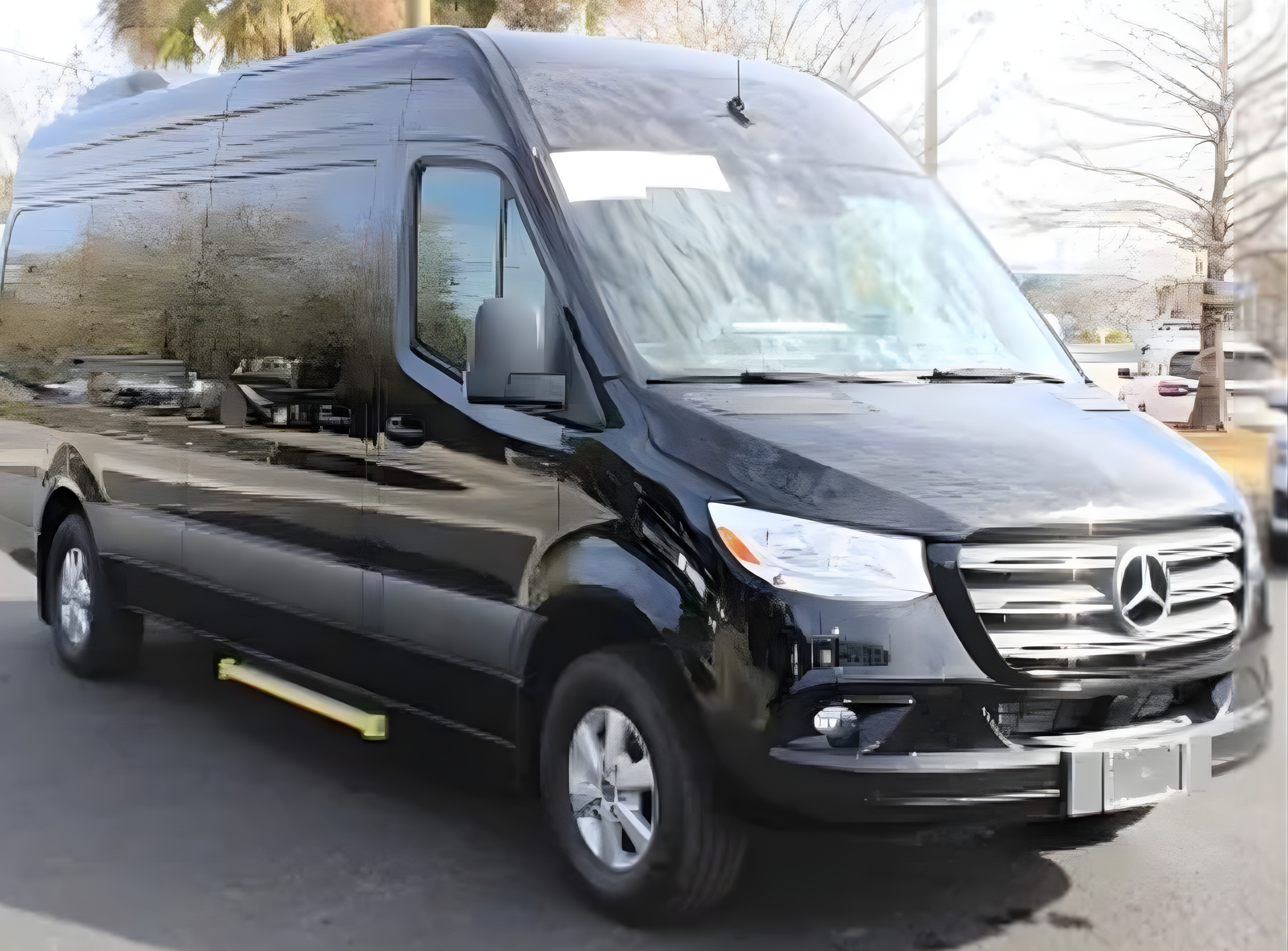 Black Mercedes-Benz Sprinter van, parked outside. Yellow step for accessibility.