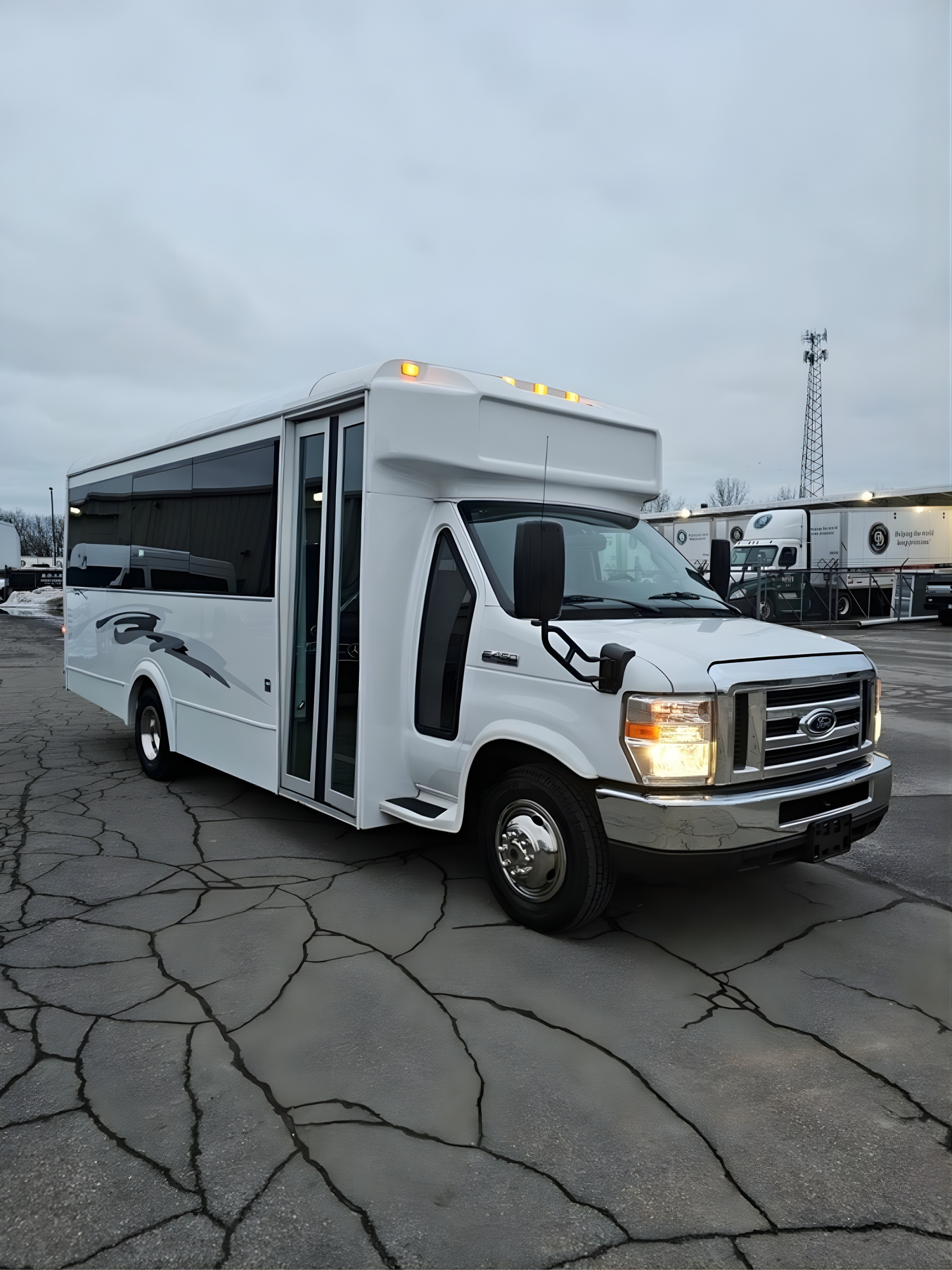 White passenger bus parked on a cracked asphalt lot, daytime.