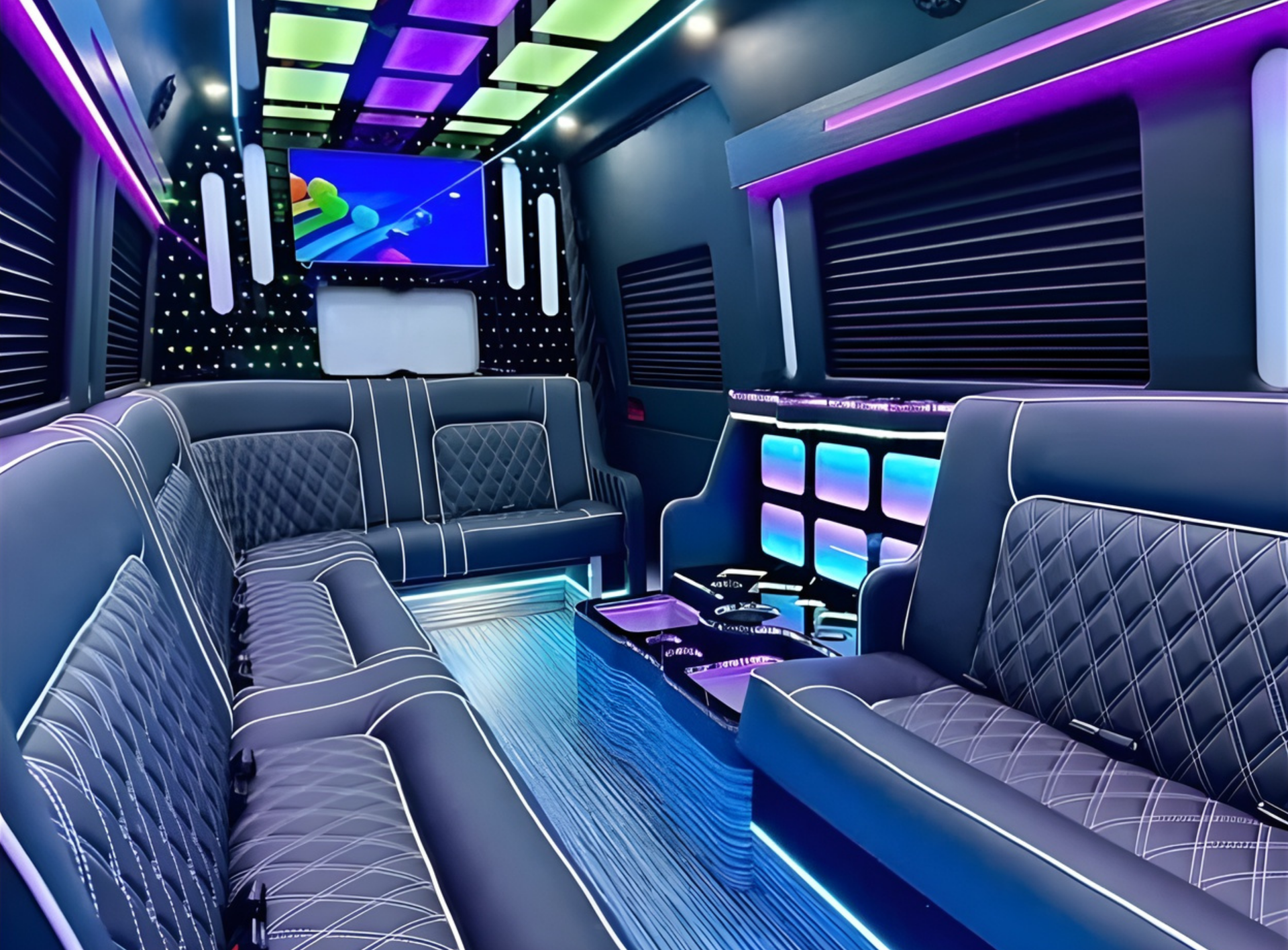 Interior of a luxury party van with black leather seating, neon lights, TV, and a bar area.