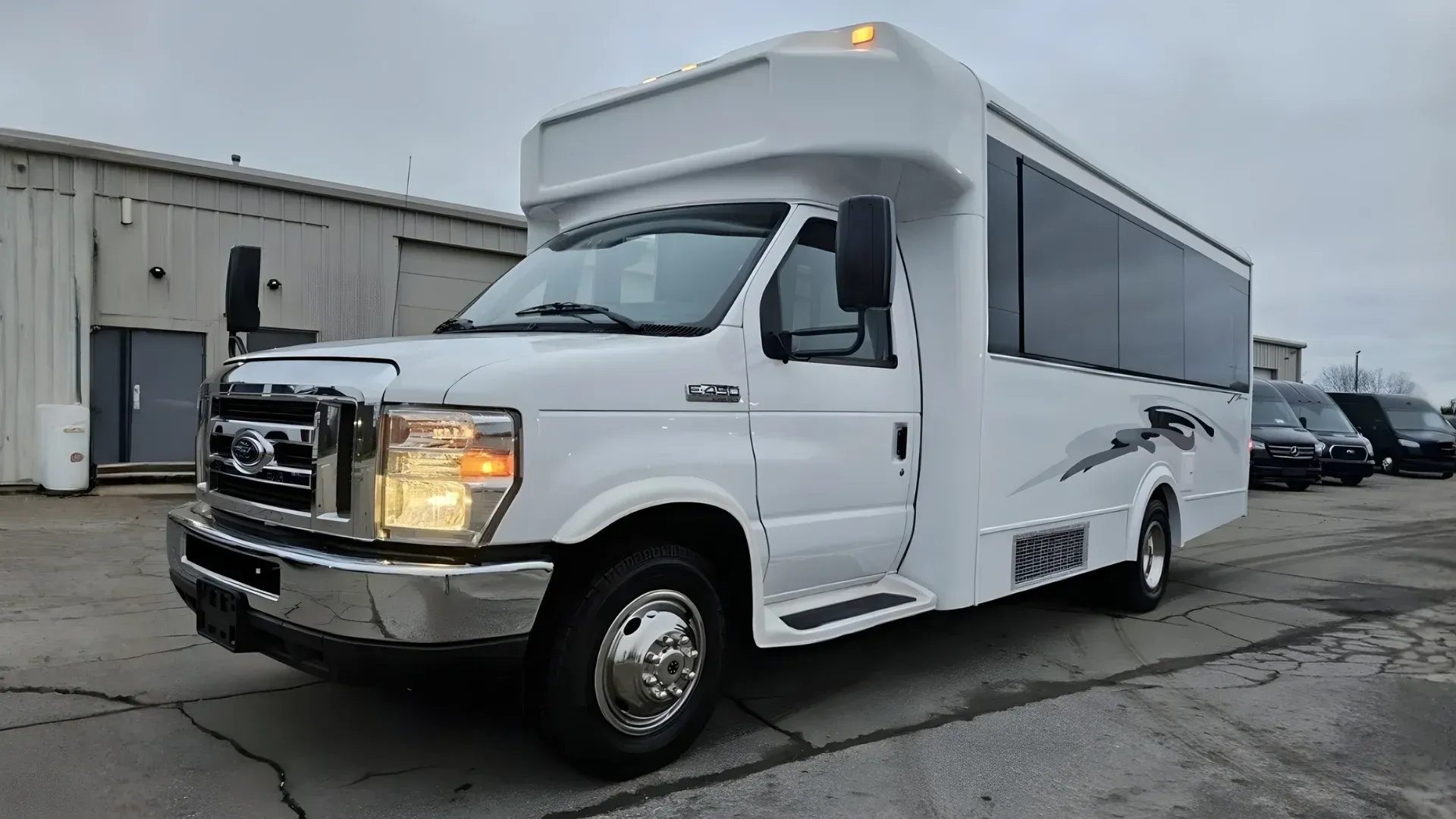 White passenger bus parked outside building.