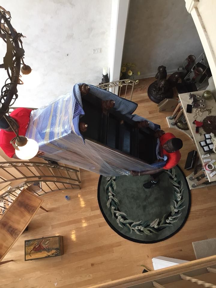 An aerial view of a piano being moved in a living room.