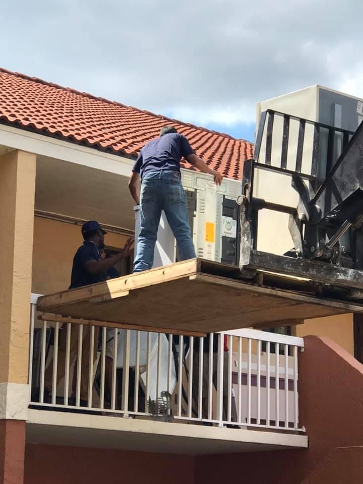 Two men are working on the roof of a building