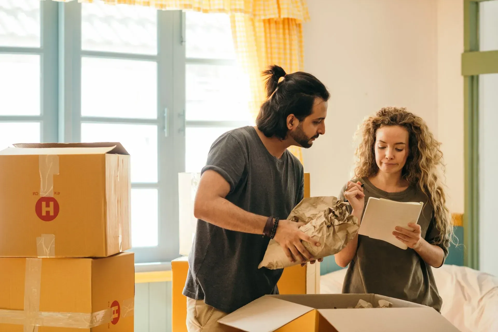 A man and a woman are moving into a new house.