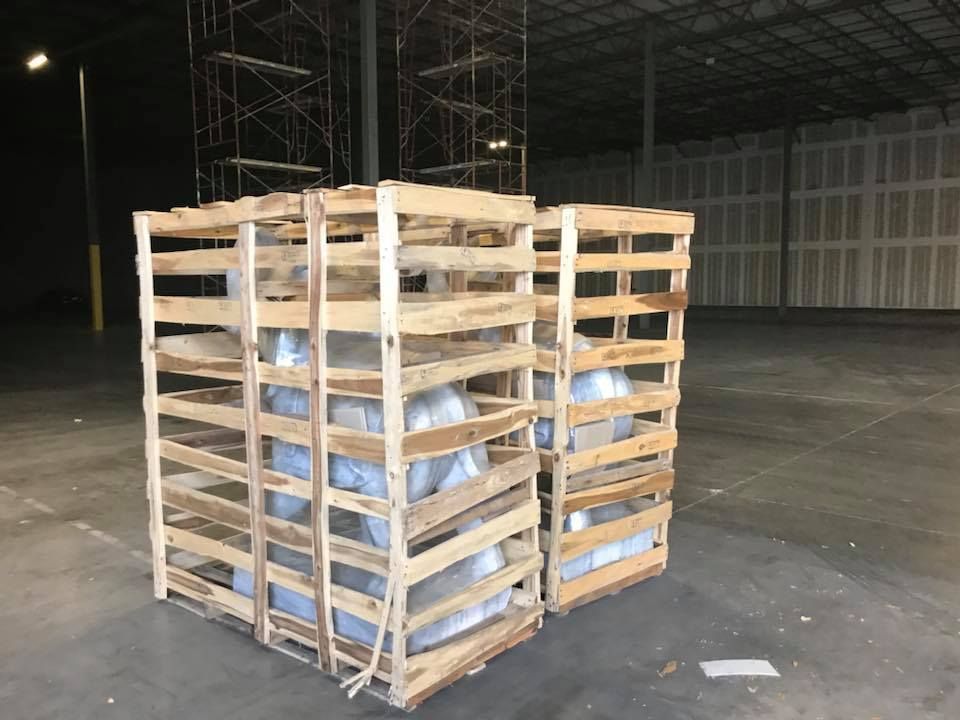 Two wooden crates filled with tires in a warehouse. 28.4845° N, 81.2519° W