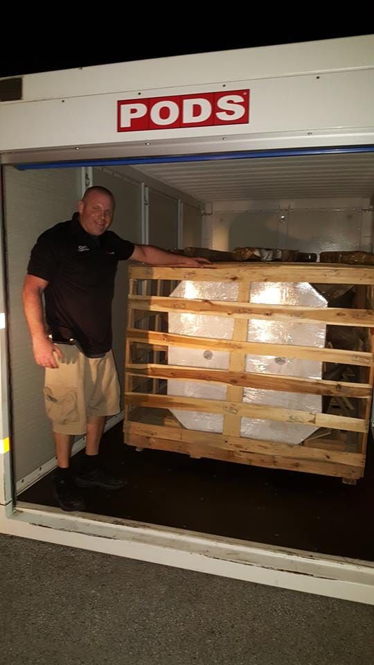 A man is standing in front of a pods sign 28.4845° N, 81.2519° W