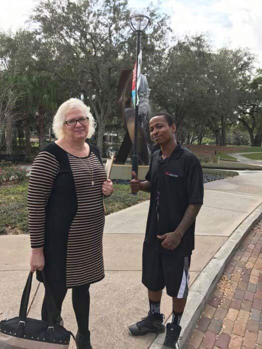 A man and a woman are standing next to each other on a sidewalk. 28.4845° N, 81.2519° W