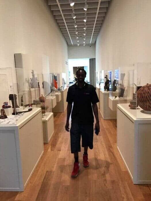 A man is walking down a long hallway in a museum. 28.4845° N, 81.2519° W