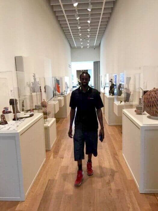 A man is walking down a hallway in a museum. 28.4845° N, 81.2519° W