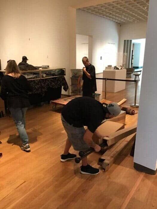 A group of people are working on a wooden floor in a room. 28.4845° N, 81.2519° W