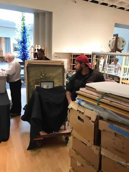 A man in a red hat is pushing a cart full of boxes 28.4845° N, 81.2519° W