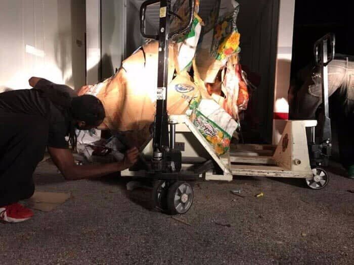 A man is working on a pallet truck in a garage. 28.4845° N, 81.2519° W