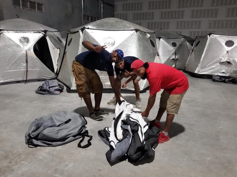 A group of men are standing in front of a row of tents 28.4845° N, 81.2519° W